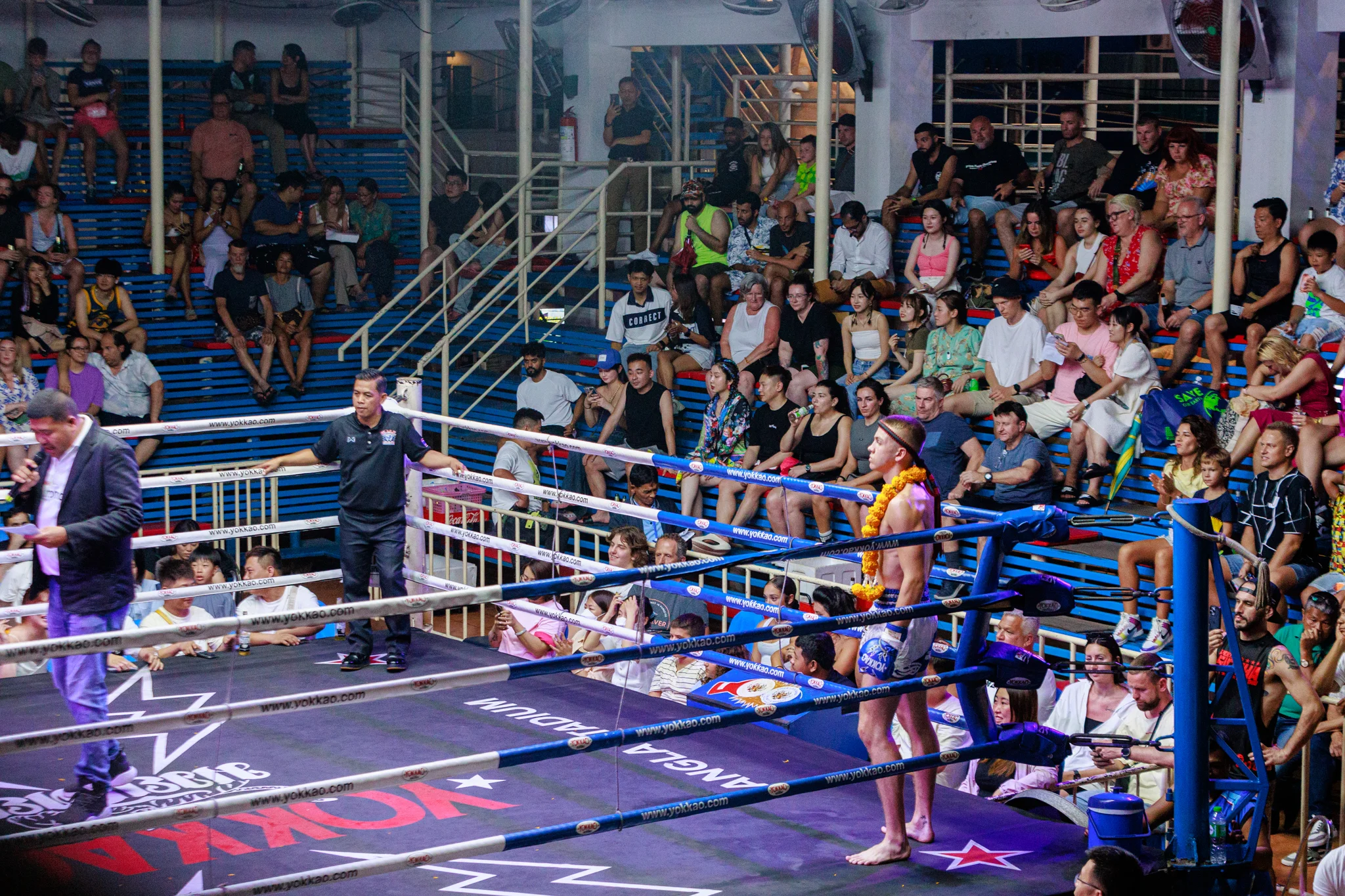 A-Thai-boxer-standing-in-a-ring-with-a-crowd-watching