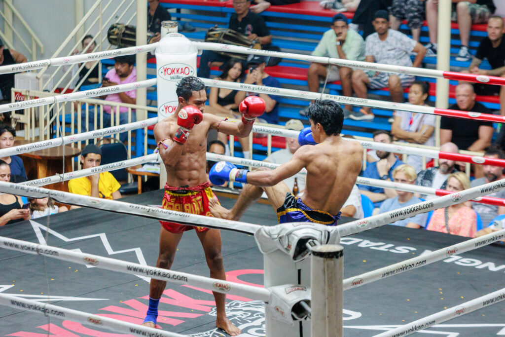 Two men boxing in a ring with a crowd watching intently