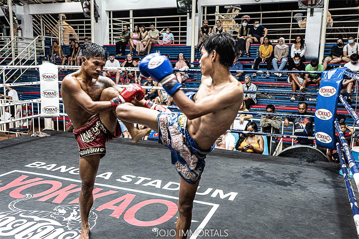 Two men boxing in a ring with a crowd watching intently