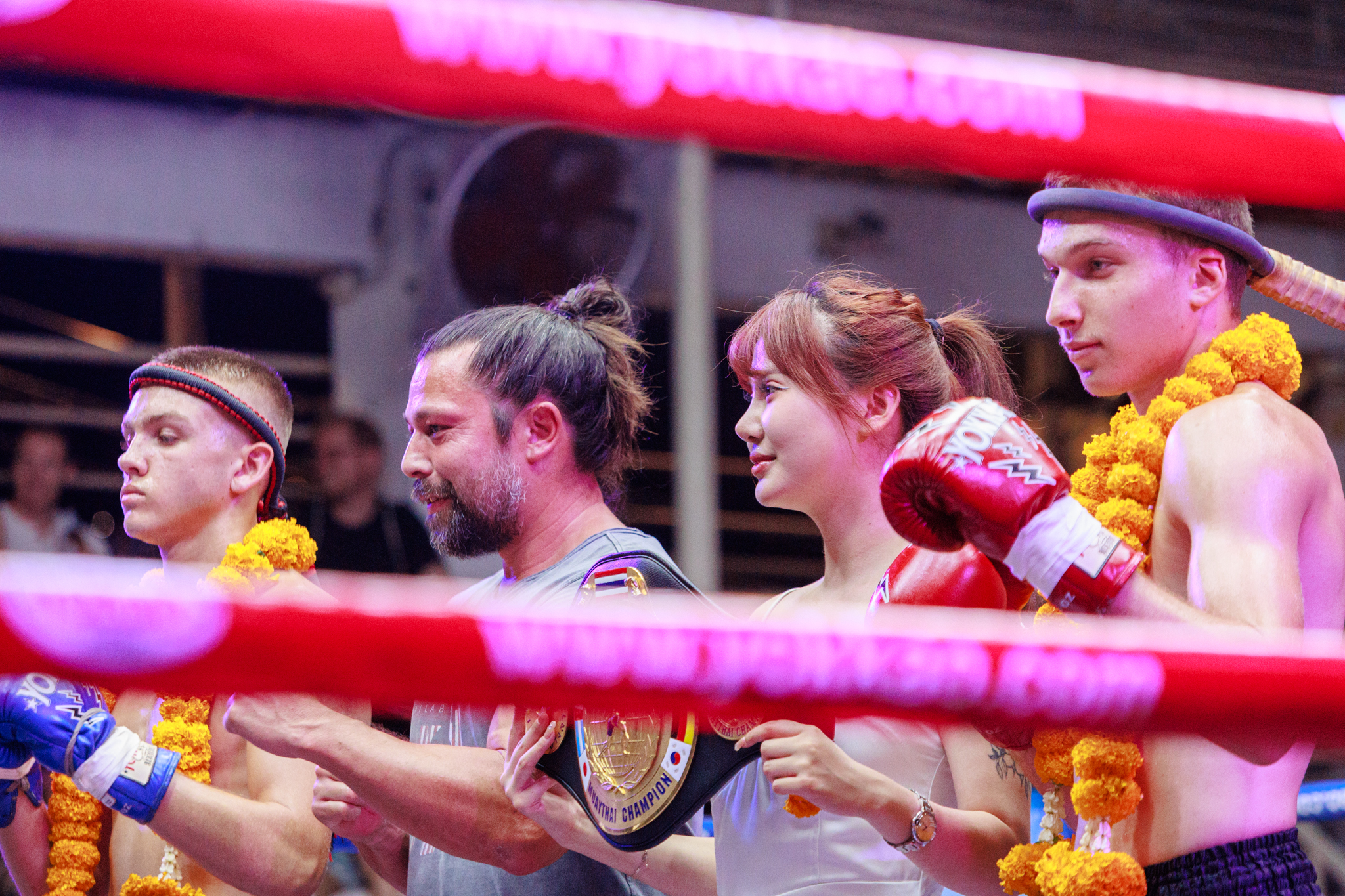 A group of people standing in a boxing ring, ready for a match.