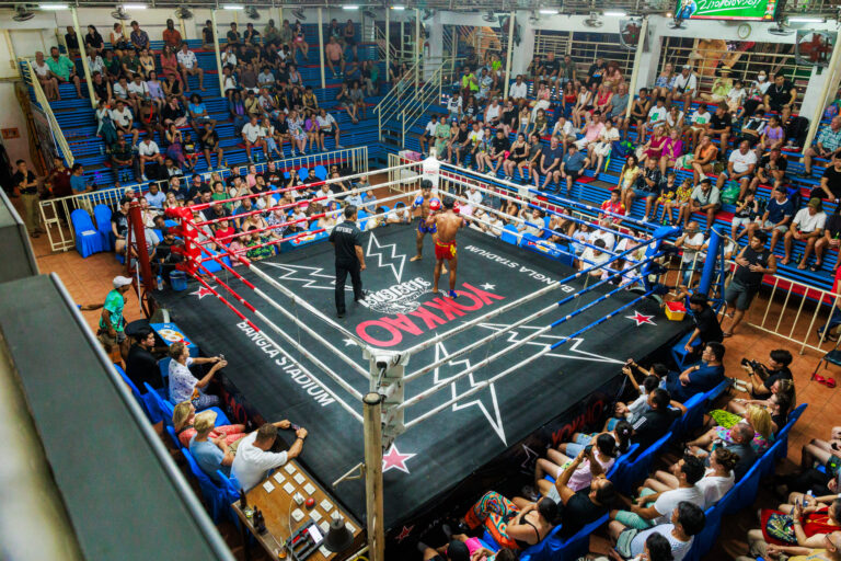 Bird's eye view of Bangla Boxing Stadium, featuring the ring and crowd of spectators.