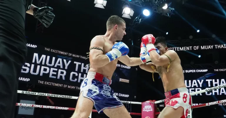 Two boxers engage in a fierce match in the ring, showcasing their skills in a dynamic display of Muay Thai fighting.