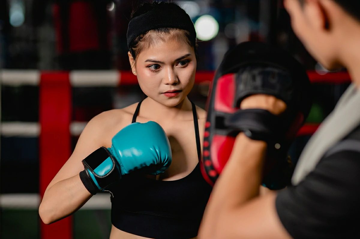 close up portrait young pretty woman exercising with handsome trainer thai boxing self defense class boxing ring gym female male fight acting selective focus