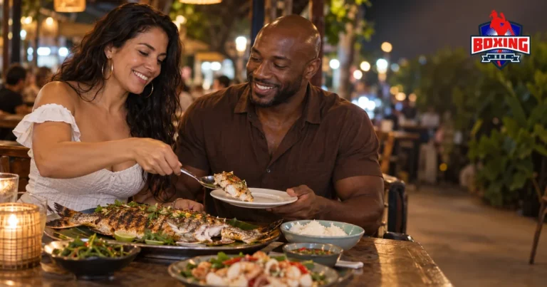 A couple sharing a late seafood dinner at a candlelit table after a fight night